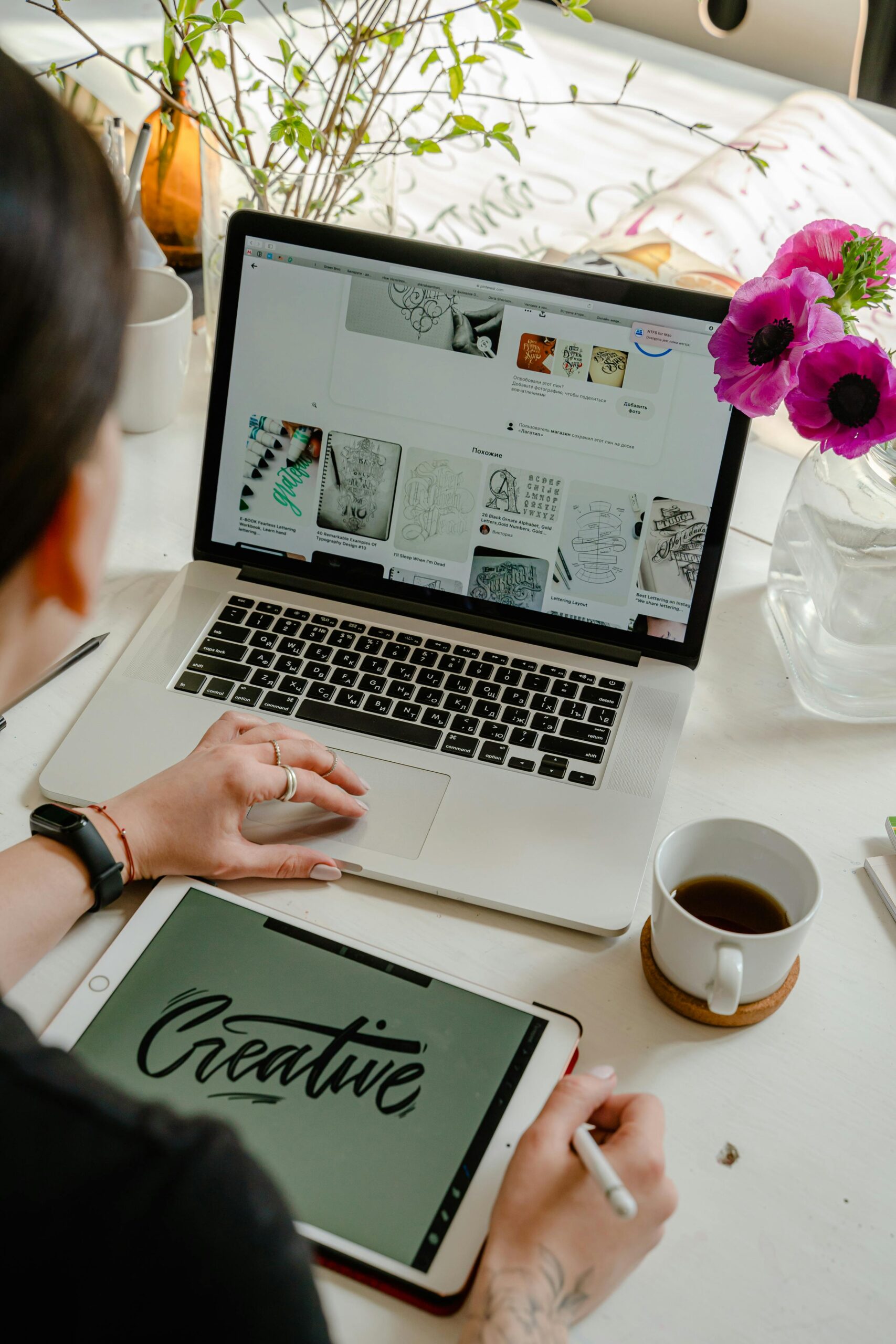 Creative work session featuring a woman using a tablet and laptop for design projects.